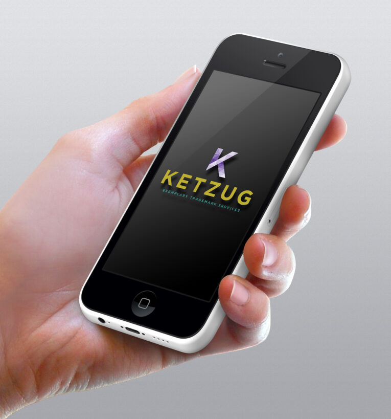 A hand holding a smartphone with the screen displaying a logo and the text "Ketzug, embodying the Five Characteristics of a Great Logo.