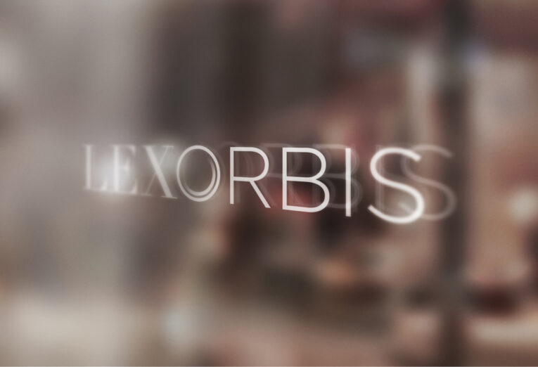 Blurred image showing the text "LEXORBIS" in white uppercase letters against an indistinct background, highlighting the five characteristics of a great logo.